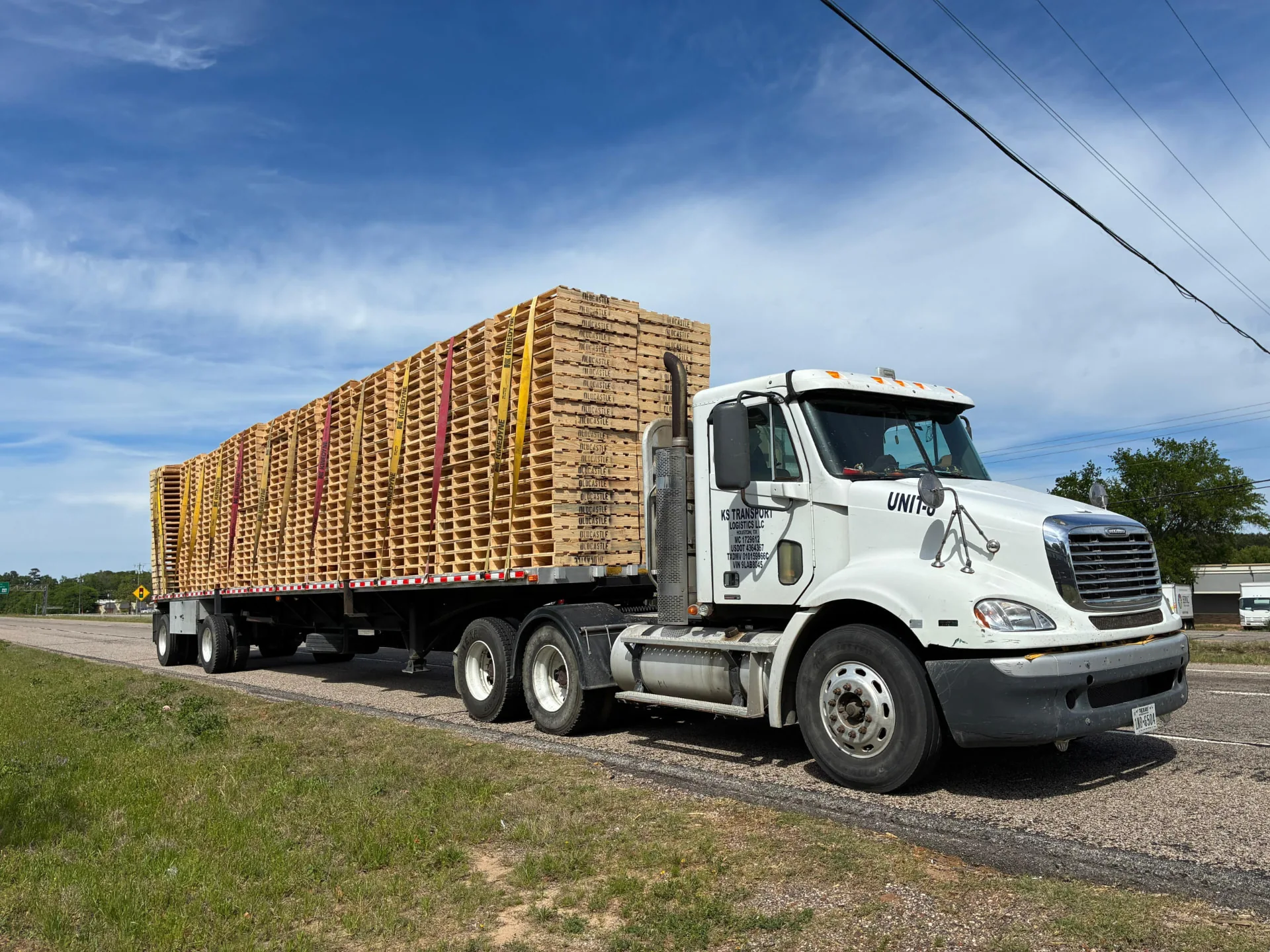 KS Transport Logistics flatbed truck loaded with palletized freight